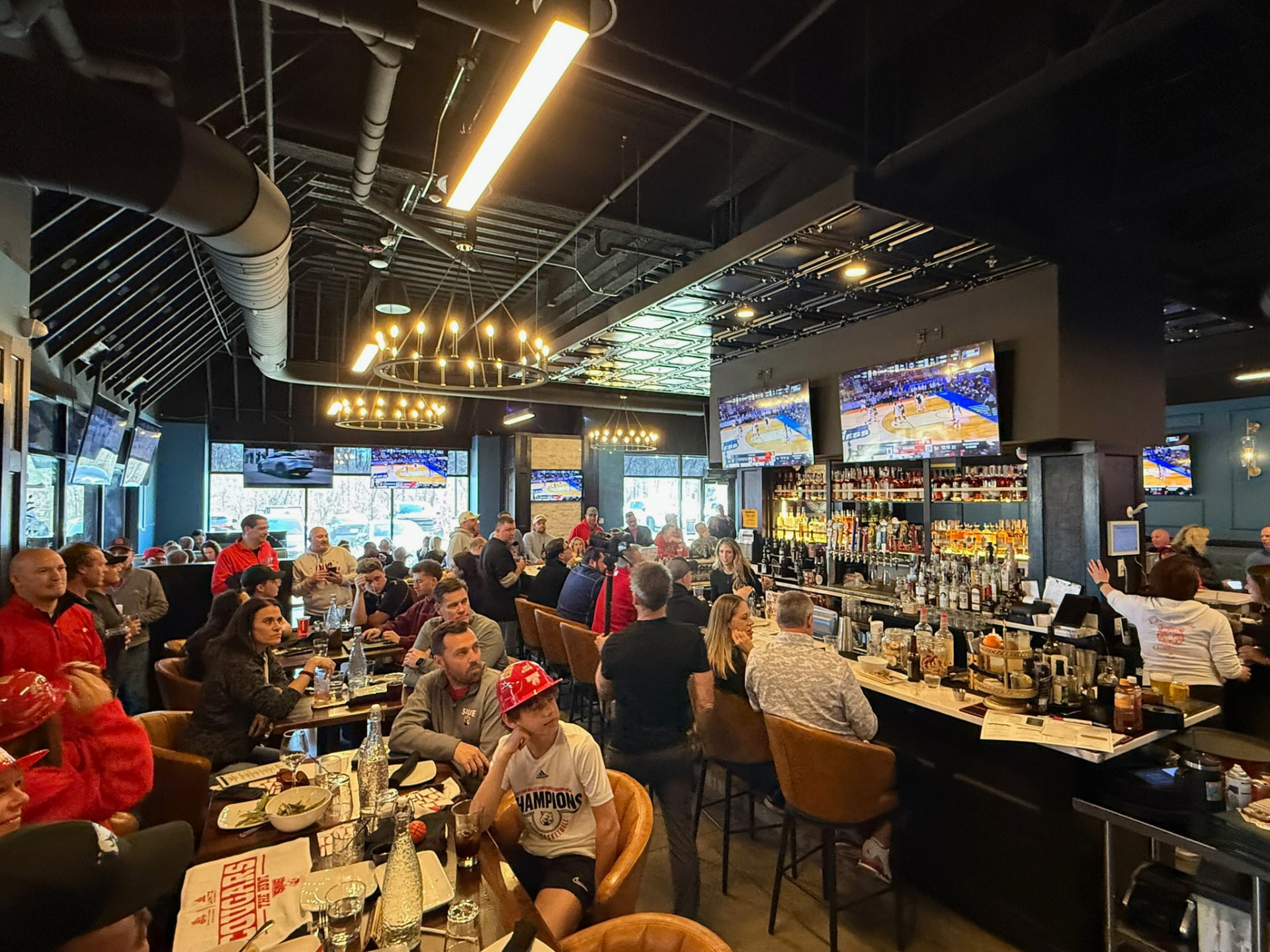 Inside Clubhouse Lounge + Kitchen in Edwardsville, with game-day TVs and seating